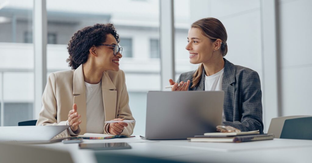 Two female coworkers discussing in the office.